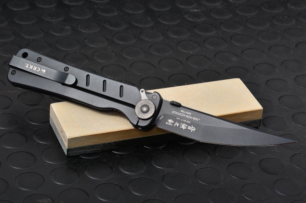 Il potere lesivo dei coltelli CRKT modello Otanashi Noh Ken, dotato di ulteriore sicura del liner. la lama in acciaio AUS 8 è lunga 1115mm. Il coltello è adagiato su una pietra belga da affilatura