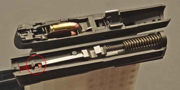 Taurus PT709: in basso, nella parte posteriore del carrello, si nota il dente della coda del percussore che, agganciato in doppia azione dalla catena di scatto del grilletto, va poi a percuotere l'innesco della cartuccia
