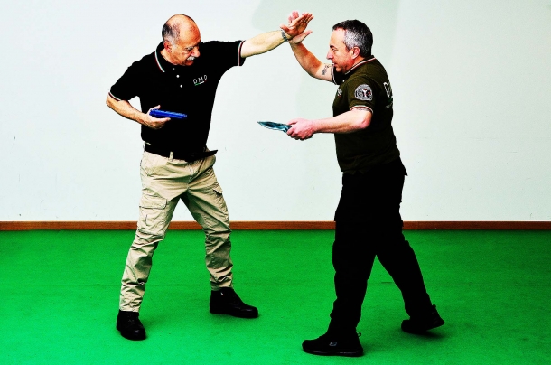 Difesa personale: tecniche di prevenzione contro la sottrazione dell’arma corta nel tiro da difesa la mano di supporto è spesso impegnata a parare i colpi dell'avversario. resta problematico se non impraticabile l'inserimento del colpo in canna . notare l'arma tenuta accanto al corpo e ruotata per evitare che il carrello arretrando si impigli nel vestiario