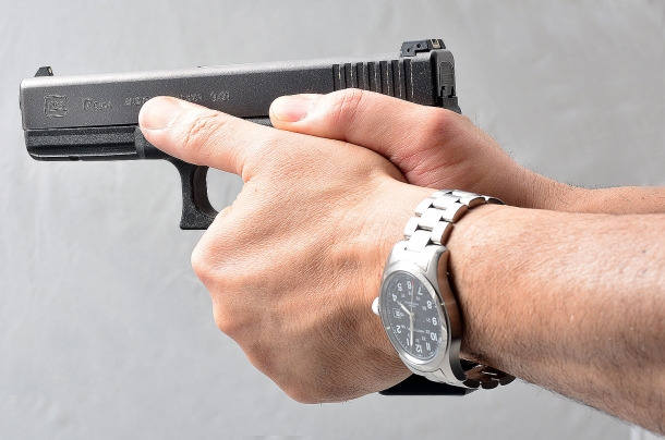 Tecnica: le impugnature errate con la pistola semiautomatica un'impugnatura corretta a due mani vista dal lato sinistro. i pollici sono indirizzati in avanti verso il bersaglio. la mano debole fascia la mano forte. non c'è aria sotto l'elsa e neanche tra l'indice e la parte inferiore del guardamano